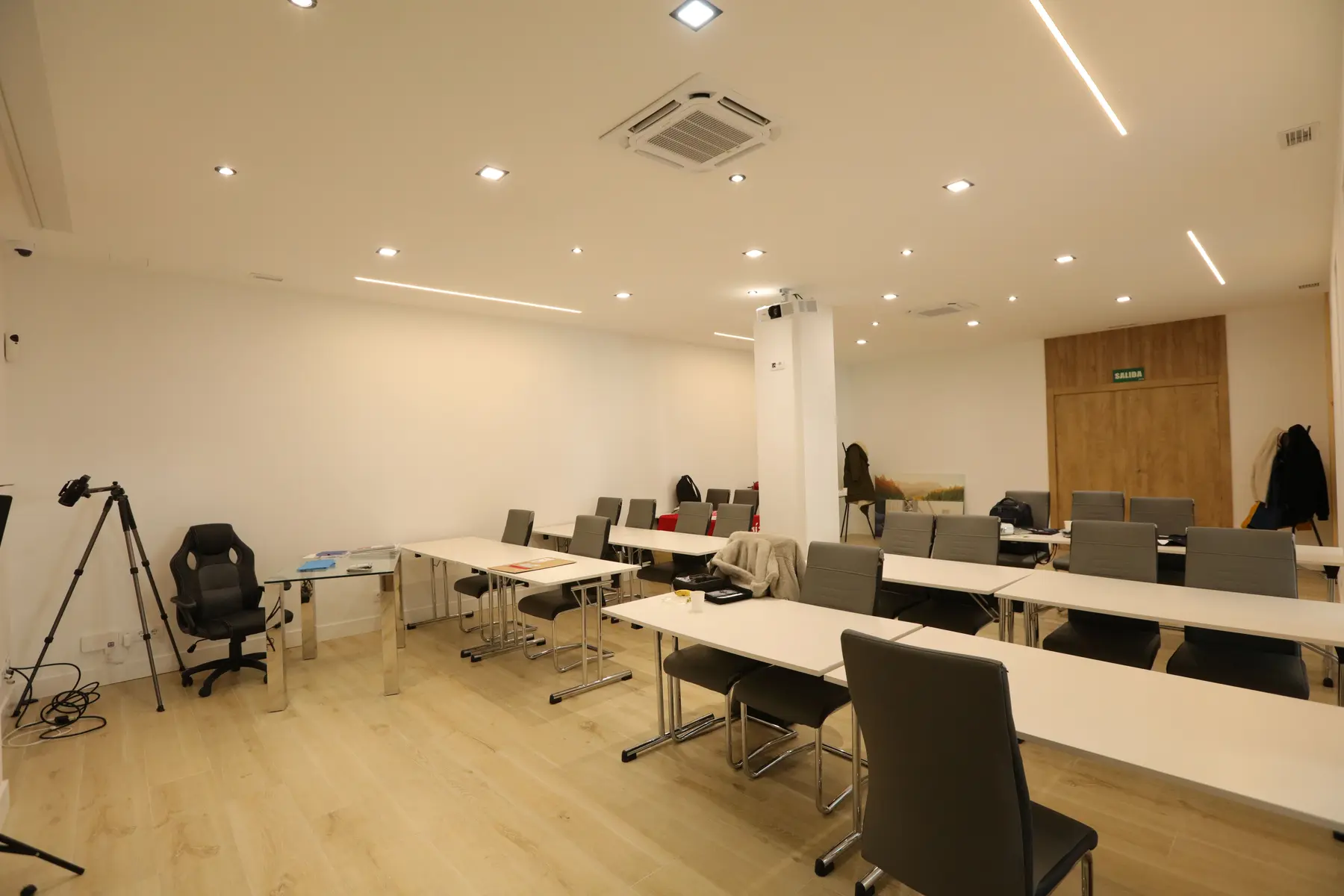 El aula principal del centro, con las mesas corridas y la tarima al fondo